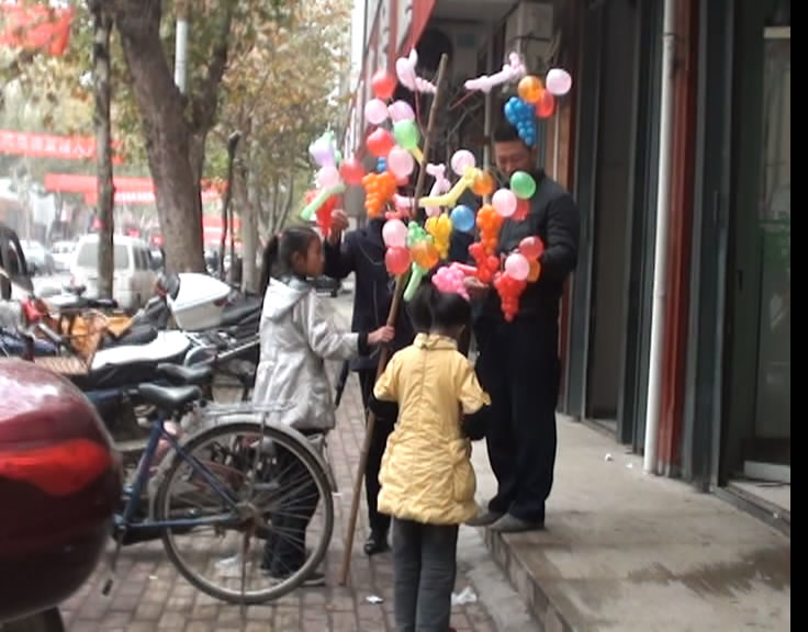 7岁女童陪10岁姐姐方城街头卖气球挣钱养家-南